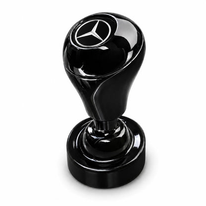 The Car Start/Stop Button Joystick is a black, glossy accessory with a round base and a handle displaying the Mercedes-Benz logo on top, adding style to your car’s interior. Shown against a white background.